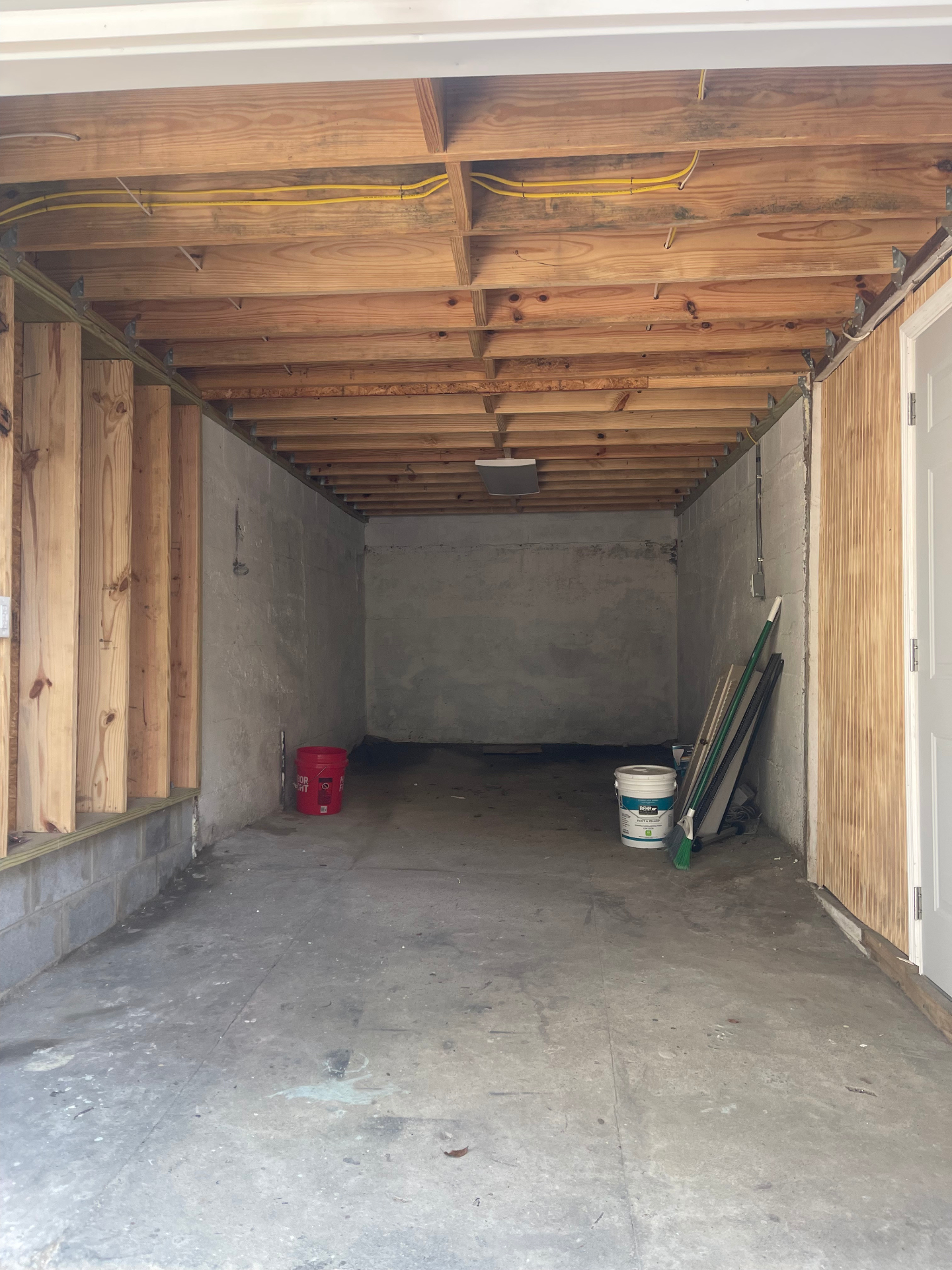Garage-level interior with floor joists and wiring - Cleveland, TN